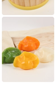 Close-up of colorful PVC dumpling models on wood tray with bamboo steamer background