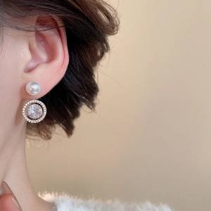 Detailed close-up of bow-knot flower earrings featuring pearls and zircon on earlobes