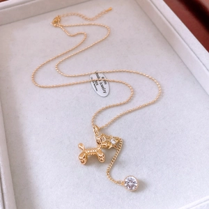 Detailed view of 14K gold-plated puppy pendant with star and cubic zirconia on tray