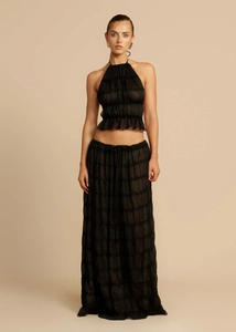 Detail view of black two-piece set featuring halter pleated top and flowing long skirt