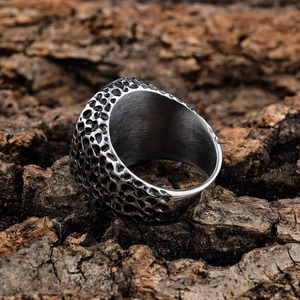 Vintage punk skull ring with silver hammered texture and wide band on bark background