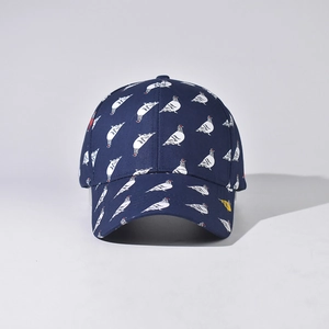 Close-up of navy blue baseball cap with white bird pattern and curved brim detail