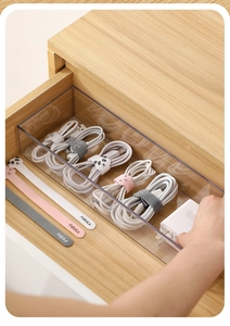 Macro detail of nylon cable ties and transparent box in a wooden drawer organizer