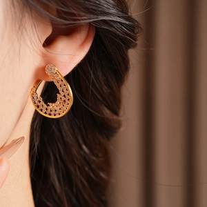 Close-up of elegant gold plated flower hoop earrings with sparkling cubic zirconia on a model