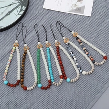 Detail view of assorted natural stone phone lanyards with tiger eye and turquoise beads