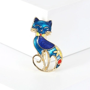 Close-up of blue enamel cat brooch with gold metal frame and floral tail details