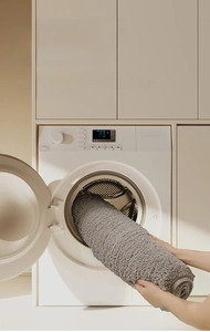 Détail du tapis de bain gris pelucheux lavable en machine montrant la fibre inaltérable