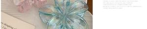 Macro view of blue pearlescent plumeria hair claw clip with iridescent finish detail