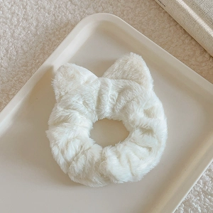Detailed view of white faux fur scrunchie with cute cat ears on a minimal display tray