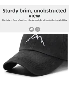 Detailed close-up of a washed black baseball cap featuring a white mountain peak embroidery