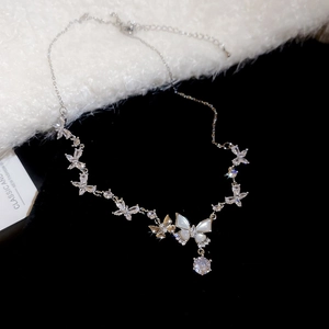 Detail of silver butterfly pendant necklace featuring zircon accents and mother of pearl