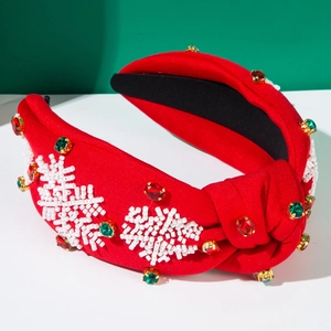 Detail eines roten Weihnachts-Haarreifs mit handgefertigten Perlen-Schneeflocken