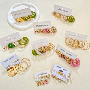 Ensemble de boucles d'oreilles mode avec perles et anneaux dorés sur présentoir