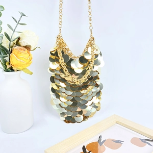 Detail of golden sequin shoulder bag with layered metallic discs and adjustable chain