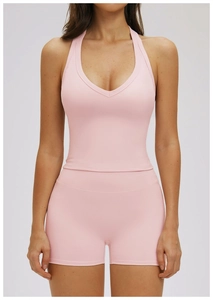 Detail of pink halter v-neck yoga sports bra and high waisted shorts on model