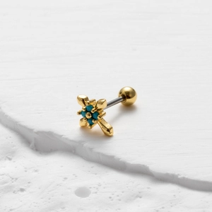 Detailed close-up of a gold cross cartilage stud earring with a turquoise center stone