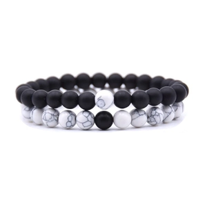 Detail of 8mm black agate and white turquoise beaded couple bracelets on white background
