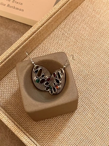Vue détaillée des boucles d'oreilles vintage ovales avec pierres colorées sur support