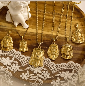 Detailed view of assorted golden Jesus head pendants on a vintage lace background