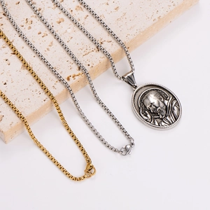 Vintage oval religious pendant necklace in silver and gold box chains on stone