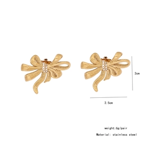 Detail of gold bow earrings with crystal inlay showing stainless steel texture and size