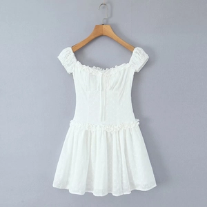 Close-up of white floral embroidery and ruffle neckline on a cotton summer dress