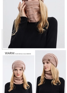 Detail eines rosa Stricksets aus Beanie und Schal mit Textur und Leder-Patch-Detail