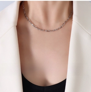 Detail of 3.4mm stainless steel O-chain necklace on model wearing a white suit