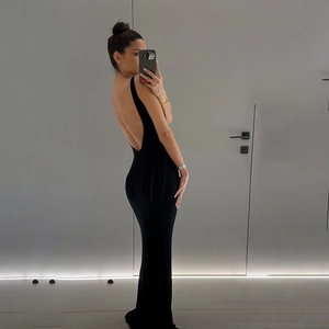 Vue arrière d'une robe maxi noire dos nu en maille moulante sur un mannequin féminin