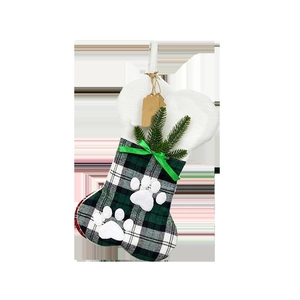 Detail of bone-shaped Christmas stocking with green plaid fabric and white plush cuff