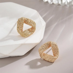 Textured gold triangle earrings with a minimalist irregular matte finish and grainy surface