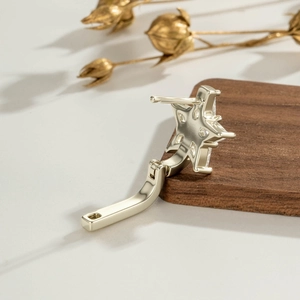 Star shaped gold earrings with kite cut zircon inlay on elegant dark wood background