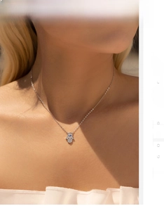 Détail du collier Main de Fatma en argent S925 avec œil bleu porté sur la clavicule