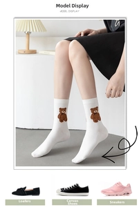 Close-up of white cotton mid-tube sock featuring brown bear embroidery and soft texture