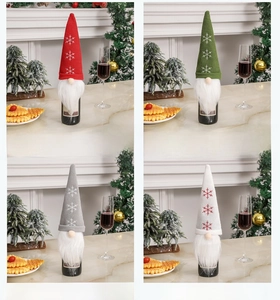 Detail of knitted Christmas gnome wine bottle covers in red, green, and grey colors