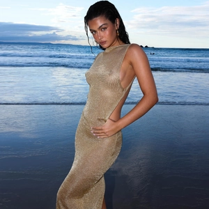 Detail of gold knitted beach maxi dress featuring open back and side cut-outs
