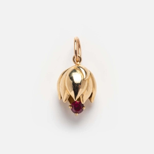 Detailed view of tulip bud pendant in gold plating with a red gemstone inset on white