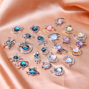 Detailed collection of celestial moon and astronaut charms on pink satin fabric background