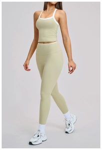 Detail van licht olijfgroene yogaset met witte contrastbiezen en racerback sporttopje