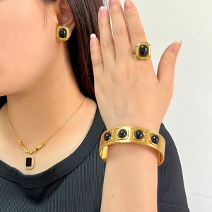 Set di gioielli dorati con pietre nere comprensivo di collana, orecchini e anello