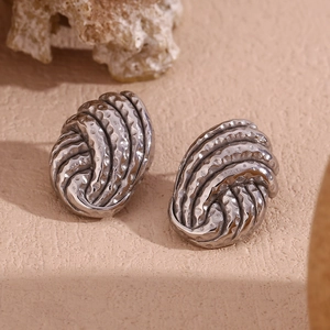 Detailed macro view of silver vintage earrings with spiral twist and hammered texture