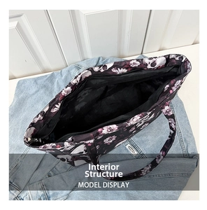 Detail view of large tote bag interior showing top zipper and floral skull print pattern
