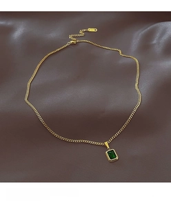 Macro view of vintage gold plated necklace featuring a rectangular emerald gemstone pendant