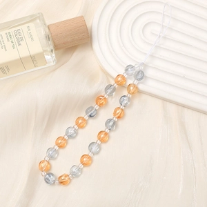Detail view of orange and blue marbled resin beads on a luxury wrist strap
