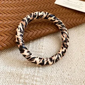 Chic leopard print open bangle featuring textured animal patterns in a classic round style