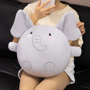 Soft round gray elephant plush pillow held by a model on a leather sofa