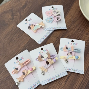 Close-up of pastel acrylic dog and star hair clips on Alline Pajamas Party display card