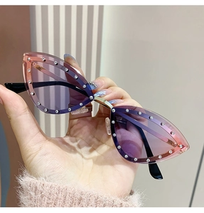Détail de lunettes de soleil œil de chat avec verres dégradés violets et strass