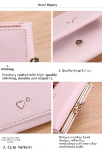 Detail view of pink leather wallet showing fine stitching, gold snap and heart decor