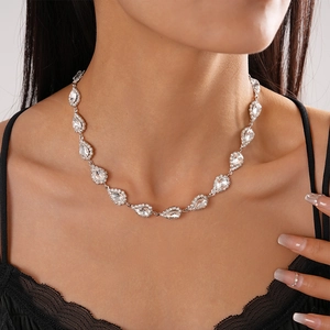 Close-up of elegant silver teardrop necklace with sparkling crystals on model's neck